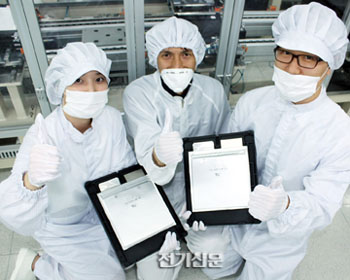 코캄 직원들이 리튬 폴리머 배터리를 들고 최고품질 표시를 하고 있다.