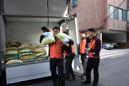 지난 12일 주복원 한전산업 사장(가운데)이 직접 봉사에 참여해 사랑의 쌀을 운반하고 있다.