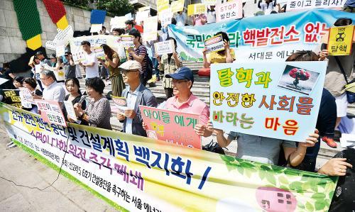 에너지자립마을 공동행동 관계자들이 25일 서울 종로구 세종문화회관 계단에서 신고리 원전 5, 6호기 건설 중단과 수명이 다한 원전 즉각 폐쇄를 촉구하는 퍼포먼스를 하고 있다.