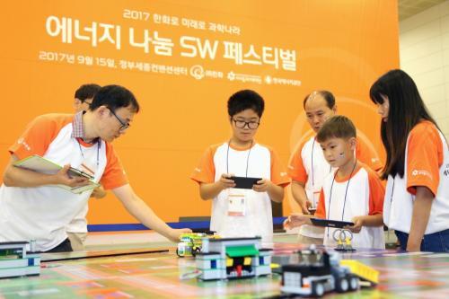 15일 한국에너지공단과 한화가 정부세종컨벤션 센터에서 개최한 ‘에너지나눔 소프트웨어 페스티벌’에서 참여 학생들이 태양광 자동차 모형을 조립해 경주를 하고 있다.