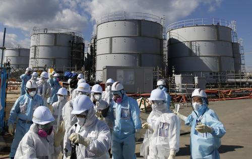 지난해 2월 보호복을 입은 기자들이 후쿠시마현 오쿠마에 있는 도쿄전력 원전의 방사성 물질 오염수 저장시설을 살펴보고 있다. 당시 지지통신은  후쿠시마 제1원전에서는 지금도 매일 400t 가량의 오염수가 증가하고 있다고 보도했다.