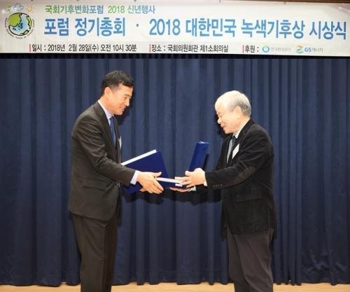 지역난방기술 송남종 전무(왼쪽)가 녹색기후변화포럼 김일중 대표(오른쪽)에게 2018 대한민국 녹색기후상 상장을 전달 받고 있다