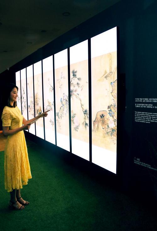 '조선 최후의 거장, 장승업 X 취화선展'을 찾은 관람객들이 LG 전자 울트라 스트레치 사이니지 8장으로 조성한  디지털병풍에서 장승업의 화조도를 감상하고 있다.