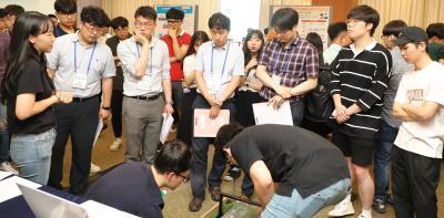 전력전자학술대회 참가자들이 I.E 경진대회에 출품된 작품에 대한 소개를 듣고 있다.