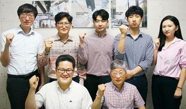 김종남 YSFS 대표(뒷줄 왼쪽에서 두 번째)를 비롯한 임직원이 최근 출시한 케이블트레이 흔들림방지 시스템의 선전을 기원하며 파이팅 포즈를 취하고 있다.