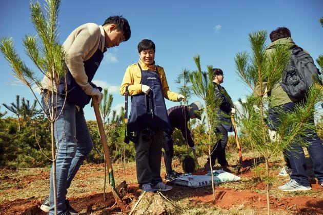 한화 '태양의 숲 조성 행사'에 참여한 시민들이 나무를 심고 있는 모습.