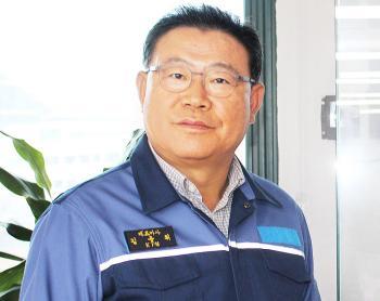 김용휘 마스텍중공업 대표가 750kW급 부유식 해상풍력터빈 모형 앞에서 포즈를 취하고 있다 