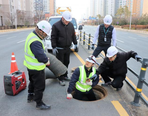 박준민 청라에너지 공사관리팀장(맨 오른쪽)을 비롯한 관계자들이 지난 8일 경기도 김포 한강신도시에서 맨홀에 진입하기 전 점검을 하고 있다.
