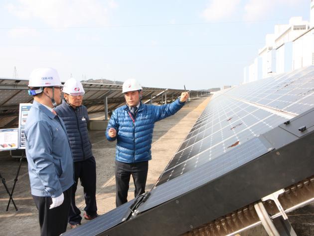 박일준 한국동서발전 사장(왼쪽)이 충남 당진화력 터빈건물 옥상을 찾아 관계자로부터 에코센스의 태양광 청소로봇에 대한 설명을 듣고 있다.