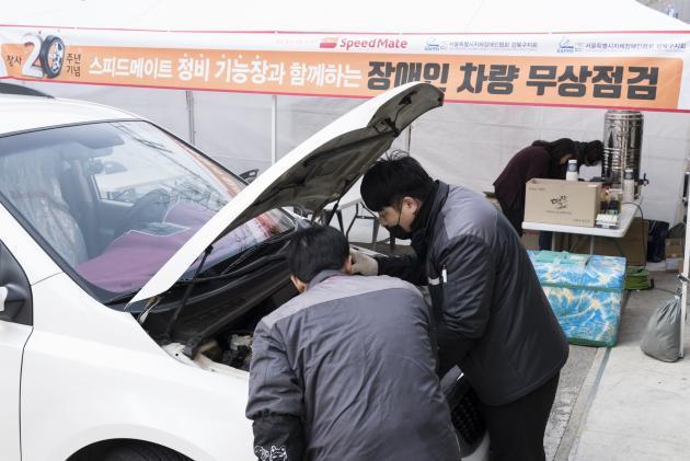 SK네트웍스 정비 기능장이 서울 성북구 소재 스피드메이트 장위점에서 장애인 차량 무상점검을 하고 있다.