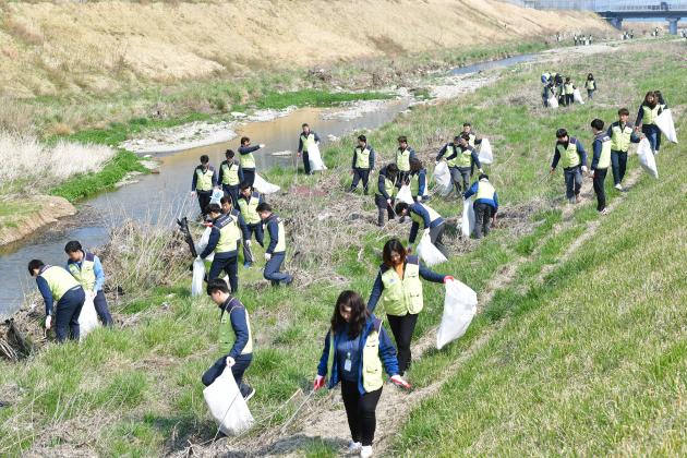 22일 세계 물의 날을 맞아 한수원 월성본부 직원 100여명이 인근 하천 환경 정화 활동에 나서 쓰레기를 수거하고 있다.