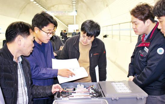 최근 개통한 부산 천마산터널 조명 시연회장에서 참석자들이 금경라이팅의 제품을 살펴보고 있다.