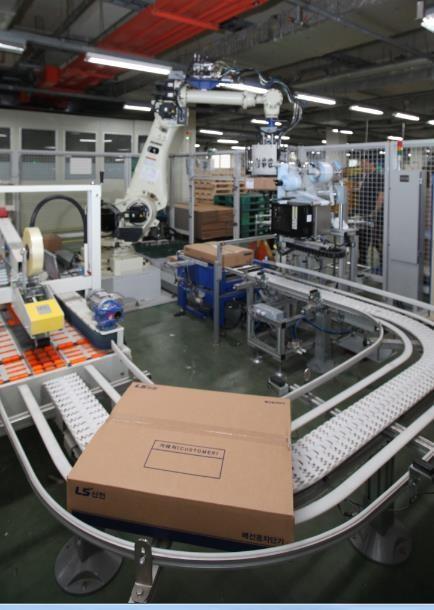 청주시 흥덕구 일반산업단지에 위치한 {LS산전} 제1사업장에서 로봇 팔이 제품을 들어올리고 있는 모습.