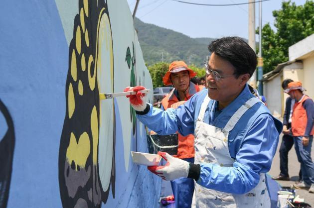 최정우 포스코 회장이 지난 24일 광양 섬거마을에서 임직원들과 함께 벽화그리기 봉사활동을 했다.