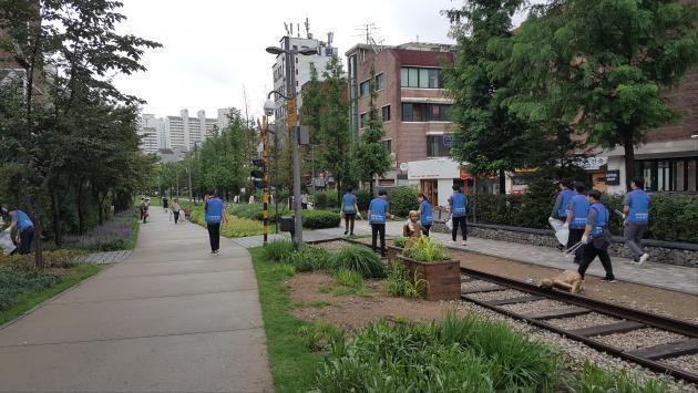전기안전공사 서울지역본부 직원들이 경의선숲길 공원 내 철길을 걸으며 환경정화 활동을 벌이고 있다.