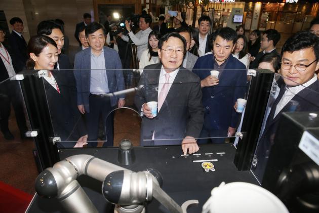 김기문 중소기업중앙회 회장을 비롯한 참석자들이 중소기업중앙회 1층 로비에 전시된 (주)로봇테크의 로봇커피머신을 체험하고 있다.