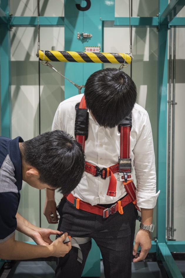 한국남부발전 하동발전본부 내 안전문화교육관에서 남부발전 관계자가 가상현실(VR)을 이용한 안전보호구 교육 체험에 앞서 기자의 안전장비를 점검하고 있다.