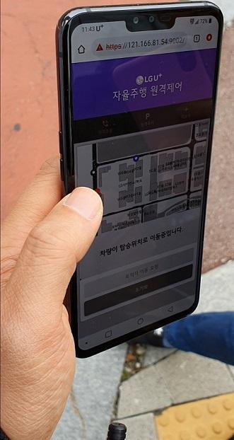 LG유플러스 직원이 휴대폰 애플리케이션을 통해 자율주행차를 호출하고 있다.