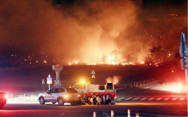 고성 산불 발생 당시 시민들이 확산하는 불길과 연기를 피해 차량 뒤에서 대피하고 있다.(제공=연합뉴스)
