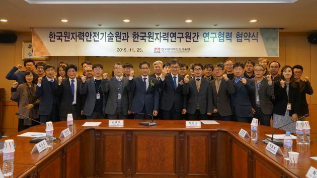 한국원자력안전기술원이 25일 본사 대회의실에서 한국원자력연구원과 체결한 연구협력 협약식에 참석한 관계자들이 기념촬영을 하고 있다.