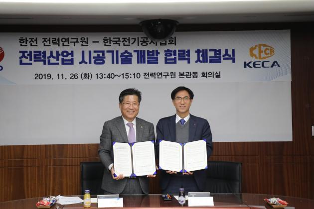 류재선 전기공사협회 회장(왼쪽)과 김숙철 전력연구원장이 협약서에 서명한 뒤 기념촬영을 하고 있다.