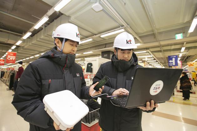 KT 네트워크부문 직원들이 경기도 안양시 홈플러스 매장 내에 고성능 광중계기를 설치하고 5G 서비스 품질을 확인하고 있다.