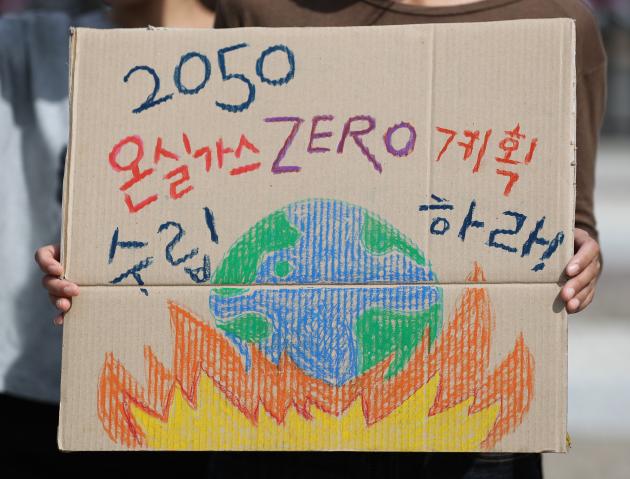 지난해 9월 서울 종로구 청와대 사랑채 앞에서 기후위기비상행동 관계자가 종이상자를 재활용한 피켓을 들고 온실가스 감축계획 수립을 촉구하고 있다. (사진은 기사의 특정 사실과 관련 없음)