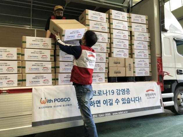 인천지역 포스코그룹사가 사회복지시설에 지원하기 위해 준비한 물품이 트럭에 실리고 있다.