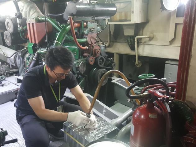 한국석유관리원 검사원이 선박연료 검사를 위해 선박 내에서 연료를 채취하고 있다.