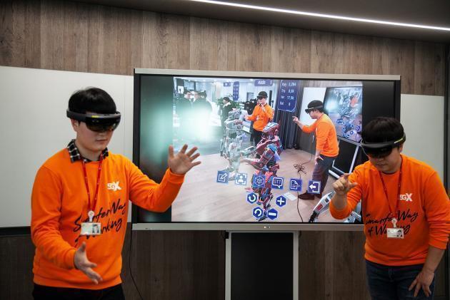 SK텔레콤 직원들이 AR글라스를 착용하고 T 리얼 텔레프리즌스로 가상공간에서 체험해 보고 있다.
