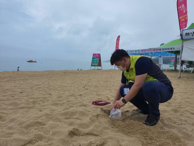 한국석유관리원 직원이 해수욕장 모래의 오염여부를 점검하기 위해 시료를 채취하고 있다.