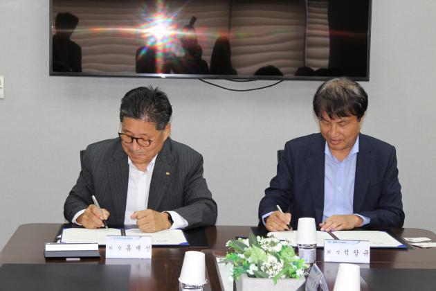 류재선 회장(왼쪽)과 석창규 회장이 ‘경리나라 보급 계약 체결식’에서 계약서에 서명하고 있다.