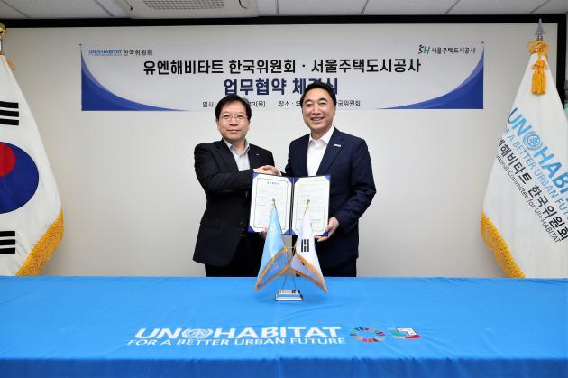 김세용 SH공사 사장(왼쪽)과 박수현 유엔해비타트 한국위원회 회장이 협약서에 서명한 뒤 악수를 나누고 있다. 