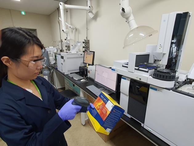 한국석유관리원 시험원이 연구 샘플을 QR 코드로 찍고 있다.