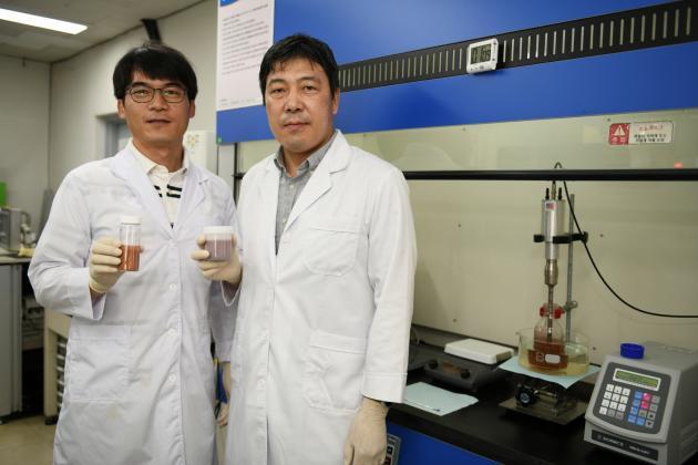 기술 개발자인 정희진 박사(왼쪽)와 이건웅 박사(오른쪽)가 금속(구리) 그래핀 복합 파우더와 잉크를 각각 들고 포즈를 취하고 있다.