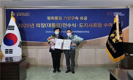 임정수 의원(오른쪽)이 민주평화통일자문회의 충북지역협의회 신영희 부의장으로부터 표창장을 전수받고 있다. 