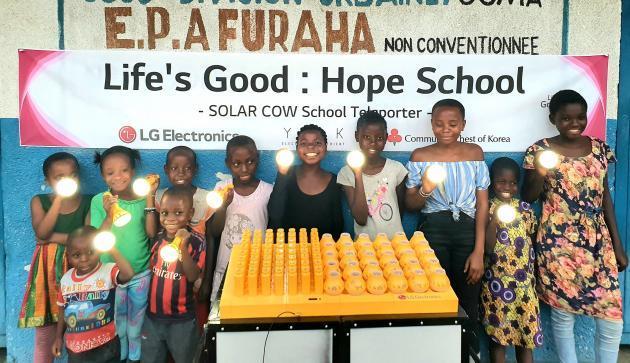 프라하(Furaha) 초등학교 학생들이 LG전자가 설치한 친환경 태양광 충전시스템 솔라카우를 이용해 충전한 휴대용 보조 배터리를 사용하며 기뻐하고 있다.