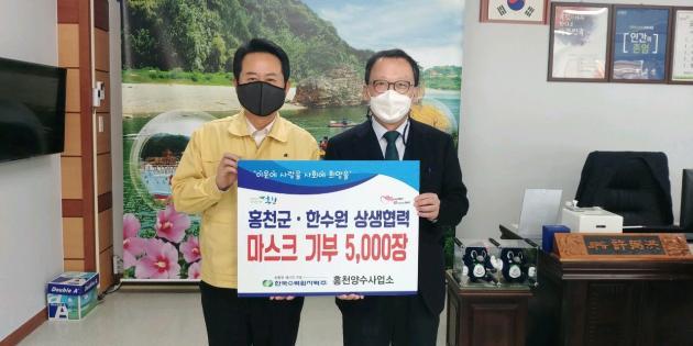 한수원 홍천양수사업소는 KF94 마스크 5000매를 홍천군에 기부했다. 이인식 한수원 그린에너지본부장(오른쪽)이 마스크를 전달한 뒤 허필홍 홍천군수와 기념촬영을 하고 있다.