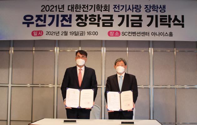 장창익 우진기전 대표(왼쪽)와 김철환 대한전기학회 회장이 장학금 기탁서에 서명한 후 협약서를 들어보이고 있다. 