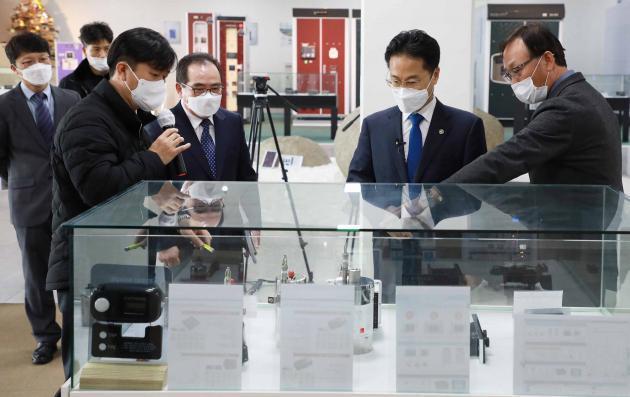 박재돈 케이디파워 대표(오른쪽 첫번째)가 김정우 조달청장(오른쪽 두번째)에게 케이디파워 제품을 설명하고 있다.