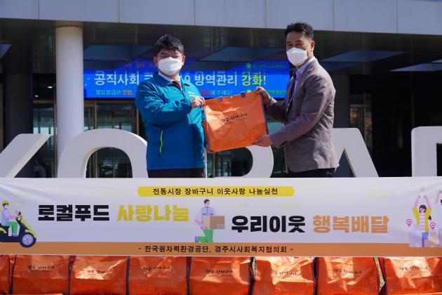 한국원자력환경공단 차성수 이사장(왼쪽)이 김종우 경주시사회복지협의회장에게 행복장바구니를 전달하고 있다.   