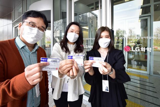 헌혈 캠페인에 참가한 LG화학 직원들이 헌혈증을 보여주고 있다.