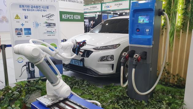모던텍 '1:N 지능형, 전기 자동차 무인충전 로봇 시스템'의 로봇팔이 전기차 충전구를 찾아 충전기 커넥터를 연결하고 있다.
