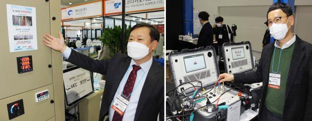 김진복 제이에스파워텍 대표(왼쪽)와 이강문 우리종합계측기 대표가 전시회에 출품한 자사 주요 제품군을 시연해보이고 있다.