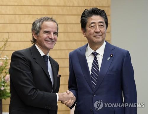 지난해 IAEA를 예방한 아베신조 당시 일본 총리(오른쪽)이 그로시 사무총장(왼쪽)을 만나 기념촬영을 하고 있다