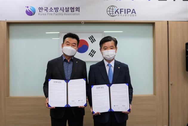 김은식 한국소방시설협회장(오른쪽)과 박종원 소방산업협회장(왼쪽)이 협약을 체결한 후 기념촬영을 하고 있다.