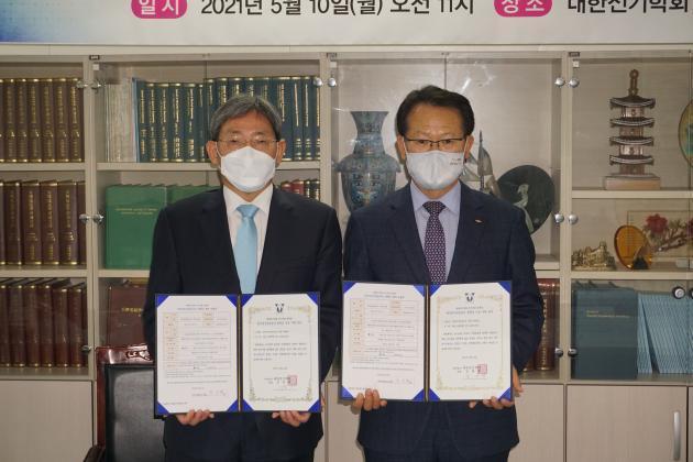 박지현 한국전기안전공사 사장(오른쪽)과 김철환 대한전기학회 회장이 전기사랑 장학금 기탁 증서에 서명한 뒤 기념사진을 찍고 있다.