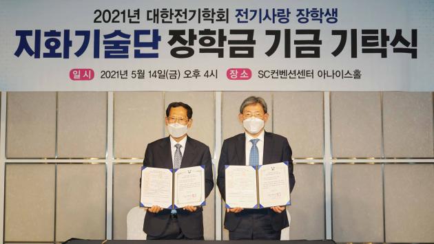 신윤용 지화기술단 대표(왼쪽)와 김철환 대한전기학회 회장이 전기사랑 장학금 기탁 증서에 서명한 뒤 기념사진을 찍고 있다.