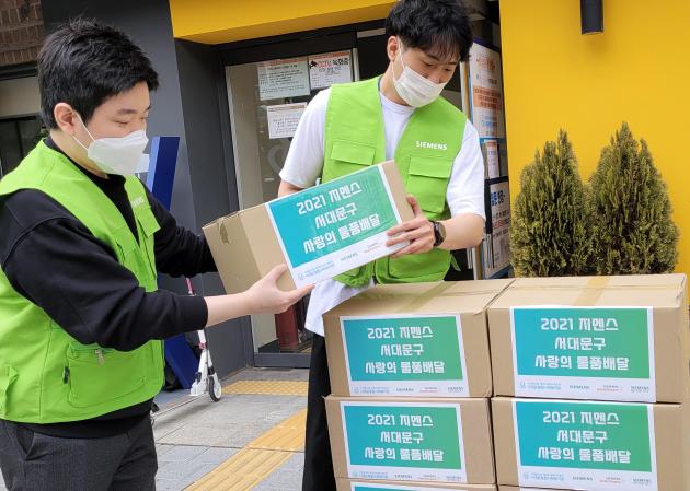한국지멘스 ‘더 나눔 봉사단’이 서대문종합사회복지관에서 230여 가구에 지원할 생필품 키트를 준비하고 있다.