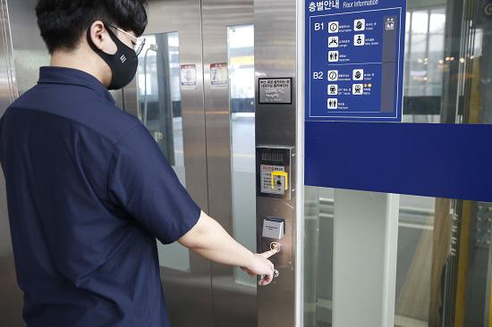 SR 직원이 코로나19 예방을 위해 상단에 자외선 살균장치가 설치된 역사내 엘리베이터 버튼을 이용하고 있다.